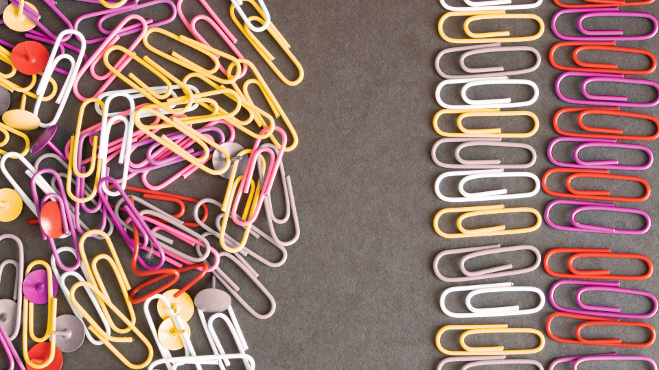Decorative image of bundled, disorganized paper clips on the right and two columns of organized paper clips on the right.